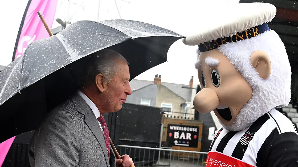 Koenig-Charles-III-und-das-Vereinsmaskottchen-The-Mighty-Mariner-bei-einem-Besuch-im-Blundell-Park-der-Heimstaette-des-Grimsby-Town-Football-Club