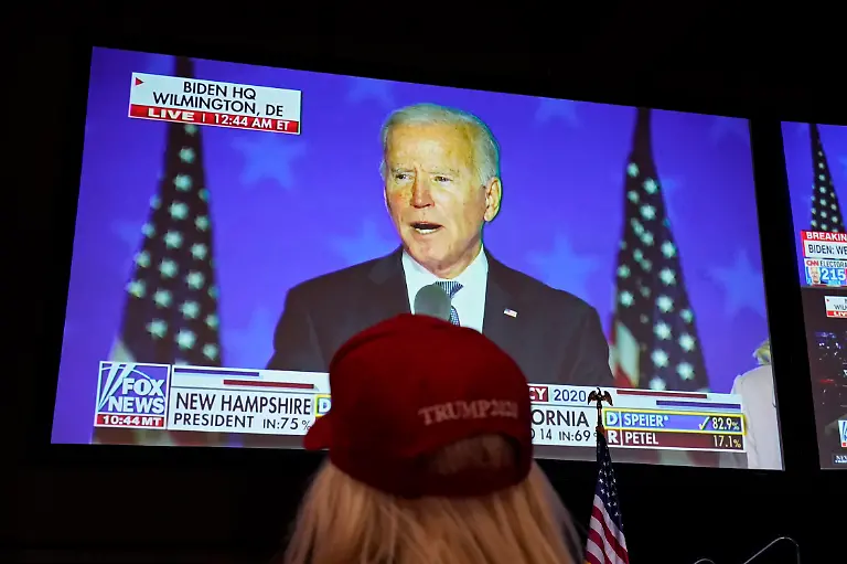 A-President-Donald-Trump-supporter-watches-as-Democratic-presidential-candidate-former-Vice-President-Joe-Biden-speaks-on-a-television-at-a-Republican-election-night-watch-party-Tuesday-Nov-3-2020-in-Las-Vegas