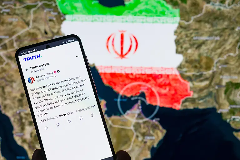 A-Truth-Social-post-by-U-S-President-Donald-Trump-is-displayed-on-a-smartphone-screen-with-the-Strait-of-Hormuz-marine-map-in-the-background-in-this-photo-illustration-as-tensions-escalate-in-the-Iran-conflict-following-his-threats-to-reopen-the-key-oil-shipping-route-Taken-in-Brussels-Belgium-on-6-April-2026