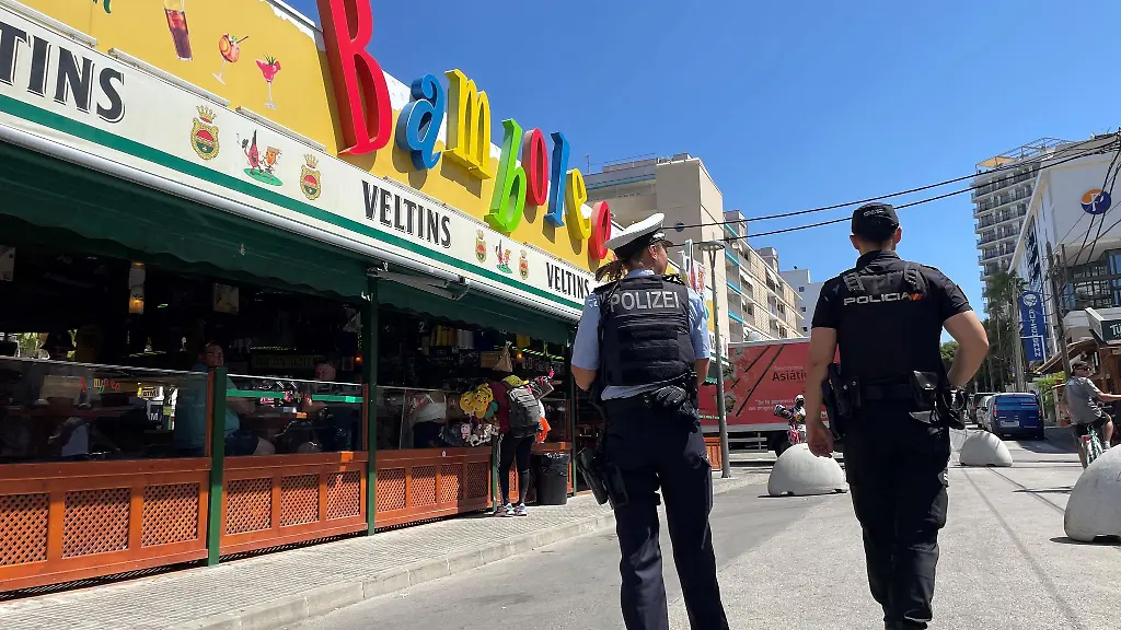 Eine-deutsche-Polizistin-laeuft-an-der-sogenannten-Schinkenstrasse-auf-Mallorca-neben-einem-spanischen-Kollegen