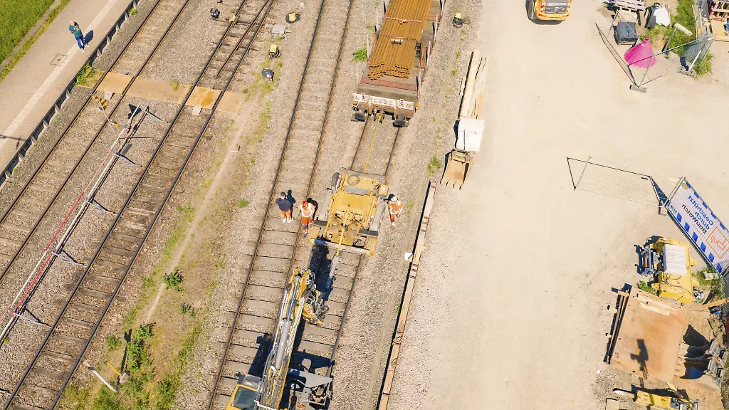 Luftaufnahme-von-Bauarbeitern-und-Maschinen-an-einem-Bahngleis-bei-sonnigem-Wetter-Elektrifizierung-der-Hochrheinbahn-Umbau-des-Bahnhof-Waldshut-Tiengen-Deutschland