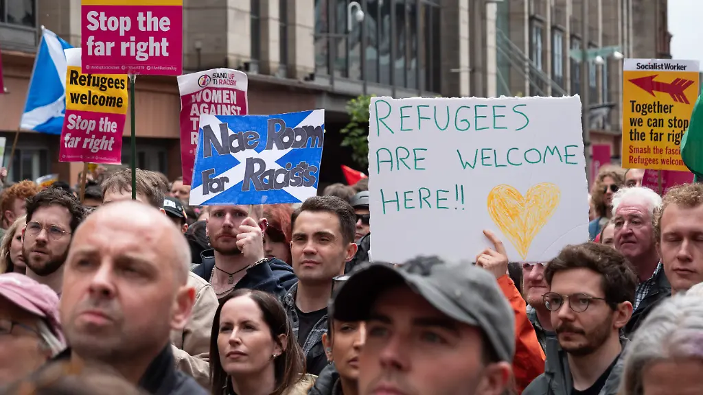 Nach-tagelangen-Unruhen-in-ganz-Schottland-im-Zusammenhang-mit-dem-juengsten-Anschlag-in-Belfast-Nordirland-kam-es-in-Glasgow-zu-Demonstrationen-rivalisierender-Gruppen-von-Befuerwortern-und-Gegnern-der-Einwanderung-Tausende-Demonstranten-die-sich-der-Organisation-Stand-Up-To-Racism-Scotland-angeschlossen-hatten-sahen-sich-dem-Widerstand-einer-kleinen-Gruppe-von-Einwanderungsgegnern-gegenueber