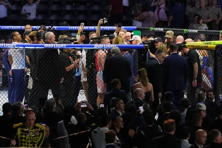 President-Donald-Trump-wearing-a-white-hat-enters-the-Octagon-to-congratulate-Justin-Gaethje-after-Gaethje-defeated-Ilia-Topuria-in-a-lightweight-title-bout-during-UFC-Freedom-250-on-the-South-Lawn-of-the-White-House-Monday-June-15-2026-in-Washington
