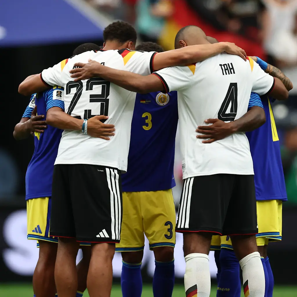 Fussball-Maenner-WM-Deutschland-Curacao-Vorrunde-Gruppe-E-1-Spieltag-Houston-Stadion-Felix-Nmecha-Deutschland-und-Jonathan-Tah-Deutschland-umarmen-Spieler-aus-Curacao-ACHTUNG-Gemaess-den-Auflagen-der-FIFA-duerfen-die-Bilder-ausschliesslich-zur-redaktionellen-Verwendung-genutzt-werden-Eine-kommerzielle-Nutzung-ist-ausgeschlossen-Zudem-duerfen-keine-videoaehnlichen-Sequenzen-erstellt-werden-und-es-duerfen-keine-Veraenderungen-weder-im-Vordergrund-noch-im-Hintergrund-am-Bild-vorgenommen-werden