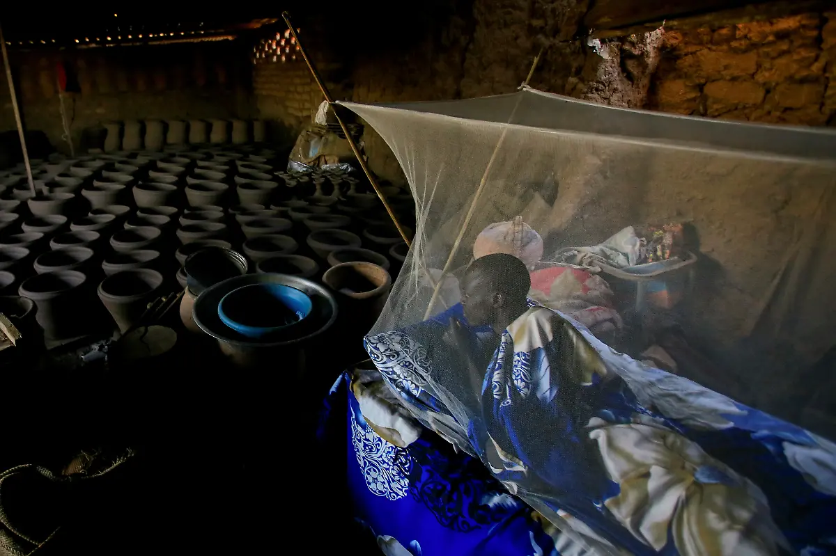 Peter-Majak-Toepfer-ruht-sich-unter-einem-Moskitonetz-in-seiner-Toepferei-aus