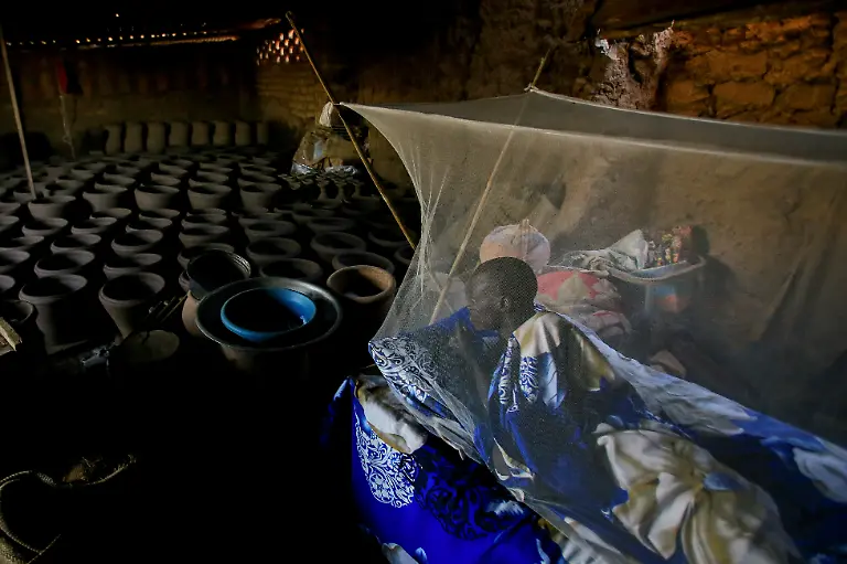 Peter-Majak-Toepfer-ruht-sich-unter-einem-Moskitonetz-in-seiner-Toepferei-aus