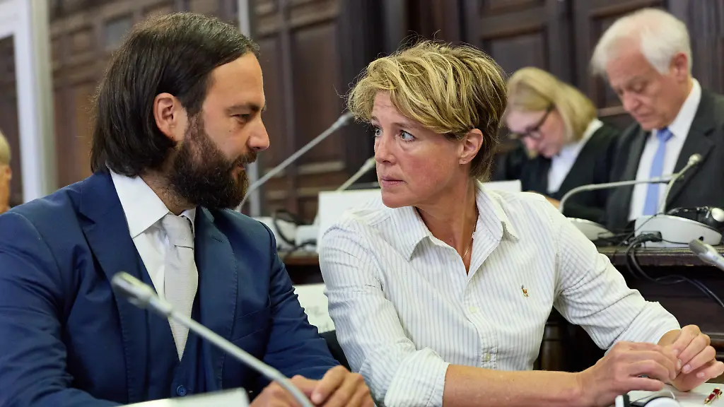 Christina-Block-M-deutsche-Gastronomin-und-Unternehmerin-Rechtsanwalt-Ingo-Bott-l-und-Rechtsanwaeltin-Paula-Wlodarek-r-Verteidiger-von-Block-sowie-ein-Uebersetzer-sitzen-im-Gerichtssaal-vor-Beginn-der-Fortsetzung-des-Prozesses-gegen-C-Block-wegen-mutmasslicher-Kindesentfuehrung-Ende-April-2025-hatte-die-Staatsanwaltschaft-Hamburg-Anklage-wegen-der-mutmasslichen-Entfuehrung-der-Kinder-aus-Daenemark-in-der-Nacht-zum-1-Januar-2024-erhoben