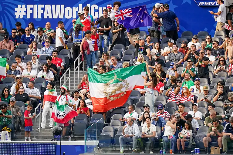 USA-Fussball-FIFA-World-Cup-WM-Weltmeisterschaft-Fussball-2026-Gruppenphase-Gruppe-G-Iran-vs-Neuseeland-SoFi-Stadium-Inglewood-Los-Angeles-County-Kalifornien-Iranische-Fans-verfolgen-das-WM-Spiel-von-den-Tribuenen-aus-und-zeigen-verschiedene-Fahnen-darunter-die-historische-iranische-Loewen-und-Sonne-Flagge-die-als-Symbol-der-Opposition-gegen-die-Islamische-Republik-gilt-Das-Motiv-steht-fuer-Fankultur-Exil-Iraner-politische-Identitaet-und-Solidaritaet-im-Umfeld-der-FIFA-Weltmeisterschaft-2026-USA-Soccer-2026-FIFA-World-Cup-Group-Stage-Group-G-Iran-vs-New-Zealand-SoFi-Stadium-Inglewood-Los-Angeles-County-California-Iranian-fans-watch-the-World-Cup-match-from-the-stands-and-display-various-flags-including-the-historic-Iranian-Lion-and-Sun-flag-which-is-considered-a-symbol-of-opposition-to-the-Islamic-Republic