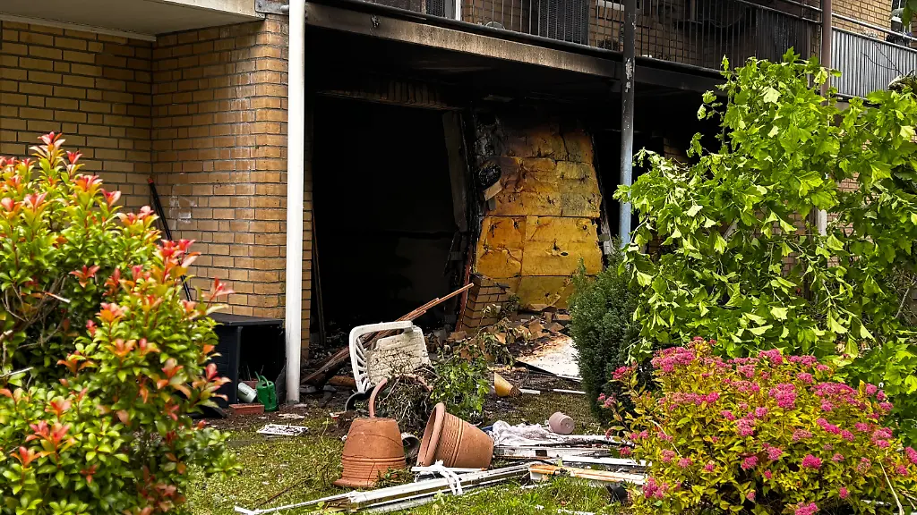 Ein-beschaedigter-Eingangsbereich-ist-nach-einer-Explosion-in-einem-Mehrfamilienhaus-in-Kropp-zu-sehen-Nach-der-Explosion-in-einem-Mehrfamilienhaus-in-Kropp-haben-die-Einsatzkraefte-einen-Toten-in-der-Brandwohnung-entdeckt