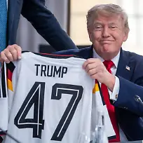 Bundeskanzler-Merz-l-CDU-schenkt-ein-DFB-Fussball-Trikot-an-US-Praesident-Donald-Trump-mit-der-Rueckennummer-47-vor-der-Arbeitssitzung-zu-den-Themen-Welthandel-Iran-und-Ukraine-Krieg-beim-G7-Treffen-in-Evian