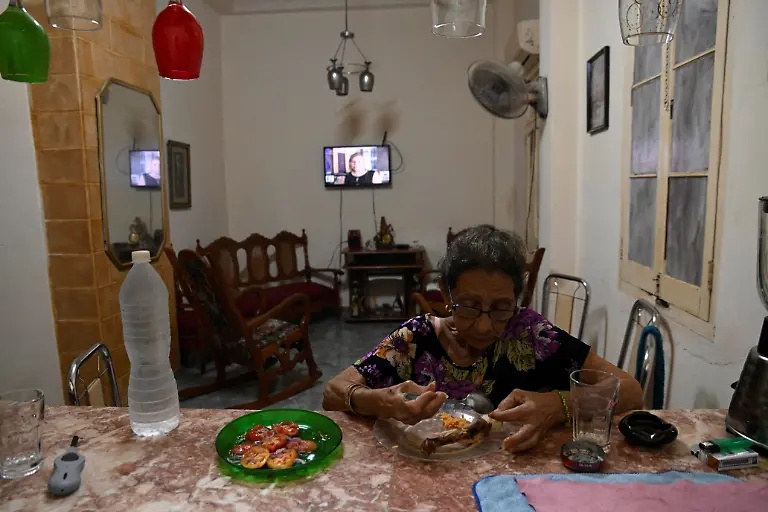 Regla-Rodriguez-70-a-widow-who-lives-off-her-work-as-a-seamstress-eats-dinner-while-listening-to-the-news-in-the-living-room-of-her-home-in-Havana-Cuba-March-12-2026-Cuba-has-struggled-for-years-under-U-S-economic-sanctions-to-deliver-on-Fidel-Castro-s-promise-that-its-communist-government-would-provide-basic-services-for-workers-subsidized-food-healthcare-education-public-transportation-and-pensions-REUTERS-Norlys-Perez-SEARCH-NORLYS-CUBA-ELDERLY-FOR-THIS-STORY-SEARCH-WIDER-IMAGE-FOR-ALL-STORIES