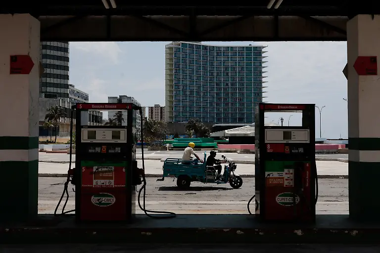 An-electric-tricycle-driver-passes-in-front-of-a-gas-station-as-Cuba-announces-new-and-variable-fuel-prices-at-the-pump-beginning-on-May-15-to-better-reflect-the-actual-costs-of-importing-gas-and-diesel-amid-an-ongoing-U-S-fuel-blockade-in-Havana-Cuba-May-12-2026