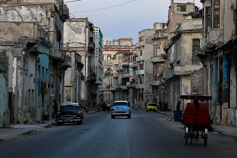 Vintage-cars-and-a-tricycle-drive-on-a-street-downtown-as-Cuba-s-state-run-economy-has-descended-into-a-full-blown-crisis-after-the-administration-of-U-S-President-Donald-Trump-hardened-sanctions-and-cut-off-the-Caribbean-nation-s-oil-supply-in-Havana-Cuba-February-21-2026