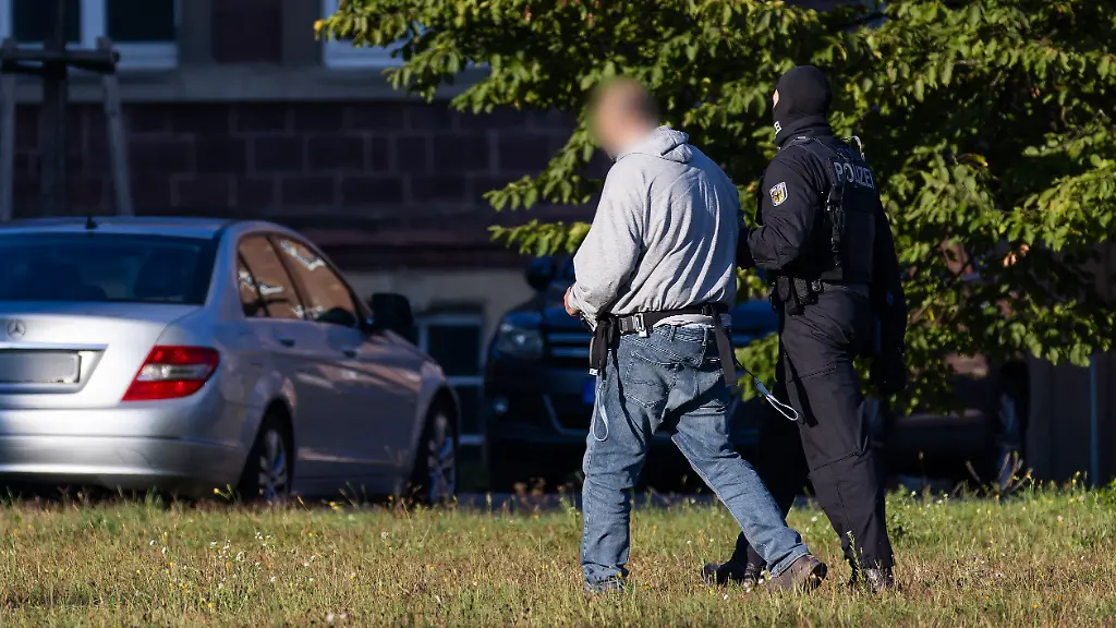 Ein-Mann-wird-von-einem-Bundespolizisten-von-einem-Helikopter-nicht-im-Bild-zu-einem-Fahrzeug-der-Bundespolizei-gefuehrt-Der-Generalbundesanwalt-hat-gestern-drei-mutmassliche-Mitglieder-der-islamistischen-Terrororganisation-Hamas-festnehmen-lassen-Die-Maenner-werden-heute-in-Karlsruhe-beim-Ermittlungsrichter-des-BGH-vorgefuehrt