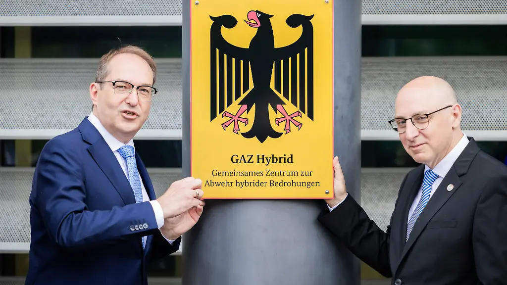 Alexander-Dobrindt-CSU-l-Bundesinnenminister-schraubt-im-Beisein-von-Sinan-Selen-Praesident-des-Bundesamtes-fuer-Verfassungsschutz-symbolisch-bei-der-Einweihung-des-Gemeinsamen-Zentrums-zur-Abwehr-hybrider-Bedrohungen-GAZ-Hybrid-das-entsprechende-Schild-an-Das-neue-Abwehrzentrum-wird-in-Raeumlichkeiten-des-Bundesamtes-fuer-Verfassungsschutz-in-Berlin-Treptow-angesiedelt-sein