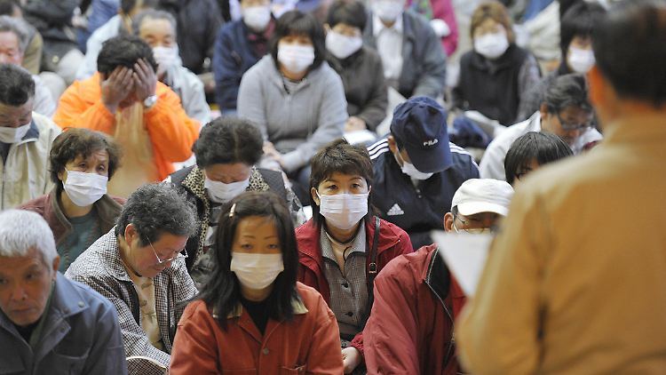 Einwohner der Dorfes Iitate, etwa 40 Kilometer vom AKW entfernt, hören ihrem  Bürgermeister Norio Sugano zu, der den neuesten Evakuierungsplan der Regierung verkündet.
