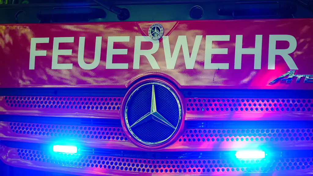 Aufschrift-Feuerwehr-auf-Feuerwehrauto-mit-Blaulicht-Symbolfoto-Blaulicht-16-06
