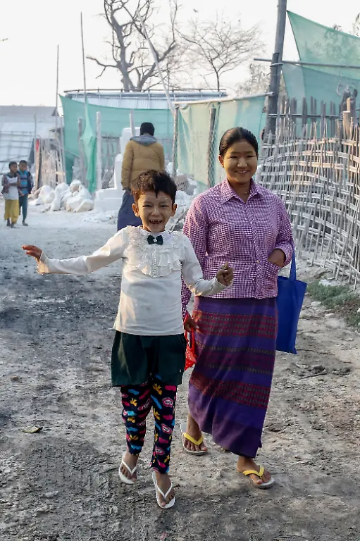 Mya-Lay-walks-25-who-used-to-work-at-a-marble-mine-but-lost-her-job-walks-her-daughter-Kyawt-Kyawt-Lwin-7-to-school-in-Sagyin