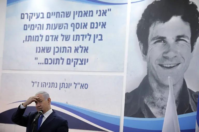 Israeli-Prime-Minister-Benjamin-Netanyahu-speaks-to-students-as-he-stands-in-front-of-a-banner-depicting-his-late-brother-Yonatan-Yoni-Netanyahu-during-a-dedication-ceremony-at-Ort-Samaria-Ulpana-school-in-the-Jewish-settlement-of-Elkana-in-the-Israeli-occupied-West-Bank-September-1-2019