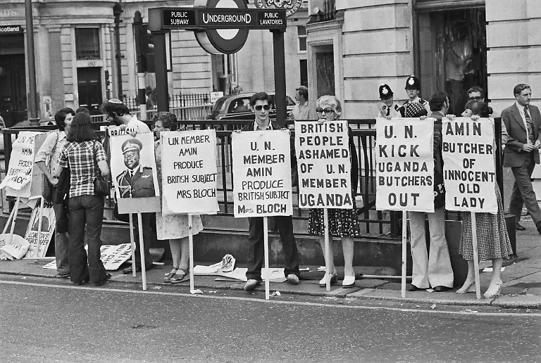 Demonstrators-with-placards-UN-Member-Amin-Produce-British-Subject-Mrs-Bloch-British-People-Ashamed-of-UN-Member-Uganda-UN-Kick-Uganda-Butchers-Out-Amin-Butcher-of-Innocent-Old-Lady-demanding-to-know-the-whereabouts-of-Dora-Bloch-during-a-demonstration-outside-Uganda-House-the-Ugandan-High-Commission-in-Trafalgar-Square-London-England-14th-July-1976-Bloch-a-British-citizen-disappeared-after-Israeli-forces-rescued-hostages-detained-by-Palestinian-hijackers-at-Entebbe-airport-in-Uganda-Bloch-s-body-was-recovered-from-near-Kampala-in-1979