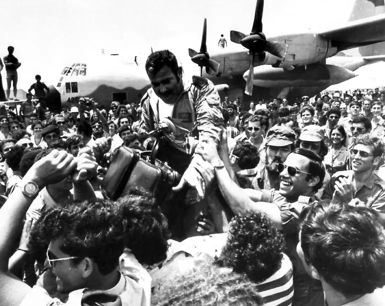 Ein-bei-der-Befreiungsaktion-beteiligter-Pilot-wird-nach-der-Rueckkehr-am-7-Juli-1976-auf-dem-Flughafen-Ben-Gurion-in-Tel-Aviv-Israel-stuermisch-gefeiert-Die-israelische-Armee-hat-in-der-Nacht-zum-4-Juli-1976-auf-dem-Flughafen-im-afrikanischen-Entebbe-Uganda-104-Geiseln-die-seit-einer-Woche-von-pro-palaestinensischen-Luftpiraten-festgehalten-wurden-befreit