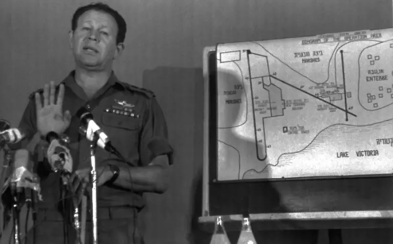 Chief-of-Staff-Lt-Gen-Mordechai-Gur-gestures-at-a-press-conference-in-Tel-Aviv-on-July-8-1976-during-which-he-gave-details-of-the-Entebbe-airport-raid-Behind-Gur-is-a-map-of-the-airport-which-the-General-did-not-use-during-his-statement