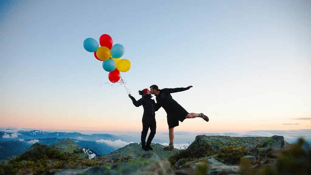 Couple-kissing-on-mountain-while-holding-balloons-Chilliwack-British-Columbia-Canada-CR-JDIP260608-2046719-01-model-released-Symbolfoto