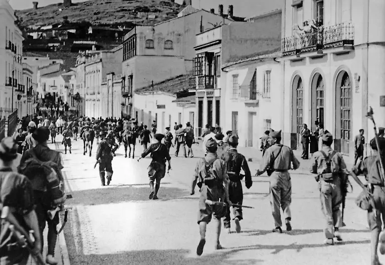 Aufnahme-von-einmarschierenden-nationalspanischen-Soldaten-in-Huelva-Andalusien-im-Sommer-1936-wenige-Wochen-nach-Ausbruch-des-Spanischen-Buergerkriegs-Vom-Balkon-begruessen-Einwohner-die-einmarschierenden-Truppen-Aufnahmedatum-17-07-1936-31-12