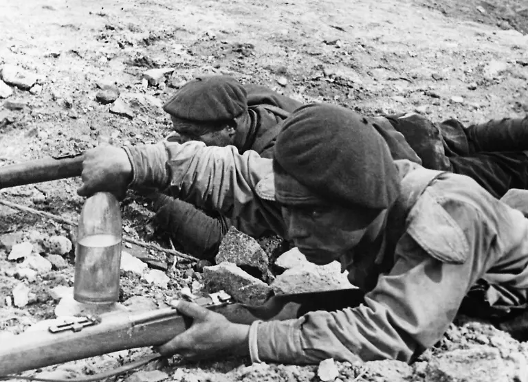 Zwei-spanische-Soldaten-an-der-Front-bei-Madrid-im-Spanischen-Buergerkrieg-beim-Werfen-einer-mit-Benzin-gefuellten-Flasche-auf-einen-Panzer-welcher-danach-mithilfe-einer-Granate-in-Brannt-gesteckt-wurde-Der-Soldat-vorn-ist-mit-einem-Gewehr-mit-einem-System-von-Mauser-bewaffnet-Aufnahmedatum-01-01-1936-31-12