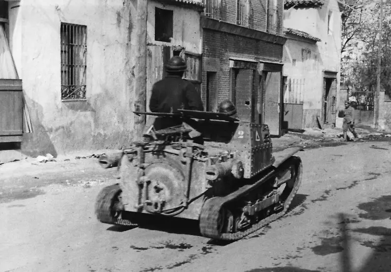 Aufnahme-des-Hecks-eines-italienischen-Zweimannpanzerwagens-L3-33-Carro-Veloce-33-der-Corpo-Truppe-Volontarie-CTV-beim-Durchmarsch-durch-das-Zentrum-von-Villaverde-del-Rio-noerdlich-von-Sevilla-Die-Besatzung-traegt-Lederhelme