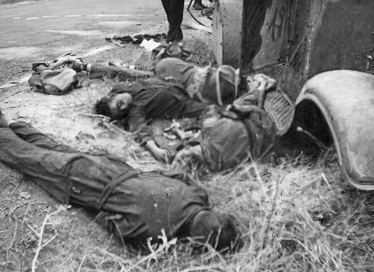 Aufnahme-einer-durch-Artilleriefeuer-getoeteter-Besatzung-waehrend-der-Schlacht-von-Talavera-de-la-Reina-85-Kilometer-vor-Madrid-Die-Gefallenen-tragen-die-blauen-Overalls-der-republikanischen-Miliz-Rechts-ist-ein-Teil-der-Karosserie-des-Panzerwagens-oben-links-die-Teerstrasse-zu-sehen