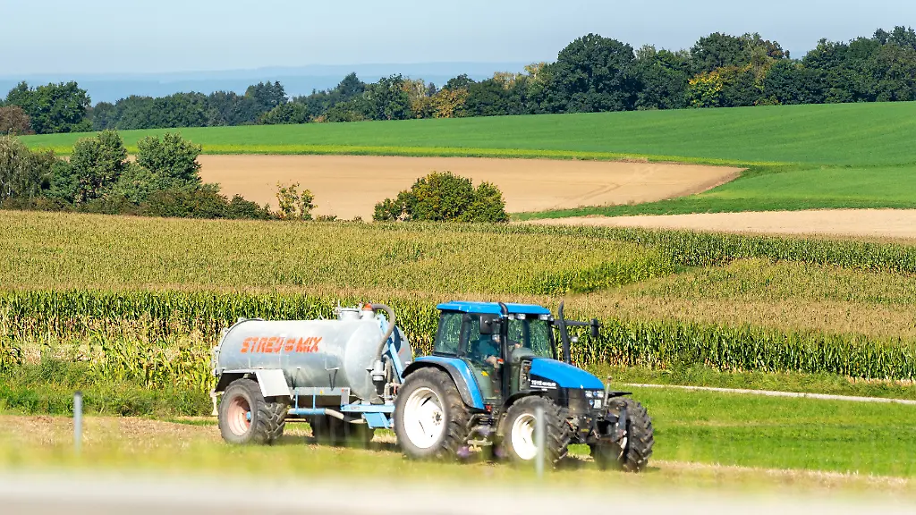 Bavaria-Germany-September-19-2025-A-farmer-drives-across-a-field-with-a-tractor-and-slurry-tanker-Slurry-is-spread-to-fertilize-the-fields-and-provide-nutrients-for-the-crops-Ein-Landwirt-faehrt-mit-einem-Traktor-und-Guellefass-ueber-das-Feld-Die-Ausbringung-von-Guelle-dient-der-Duengung-der-Ackerflaechen-und-der-Versorgung-der-Pflanzen-mit-Naehrstoffen
