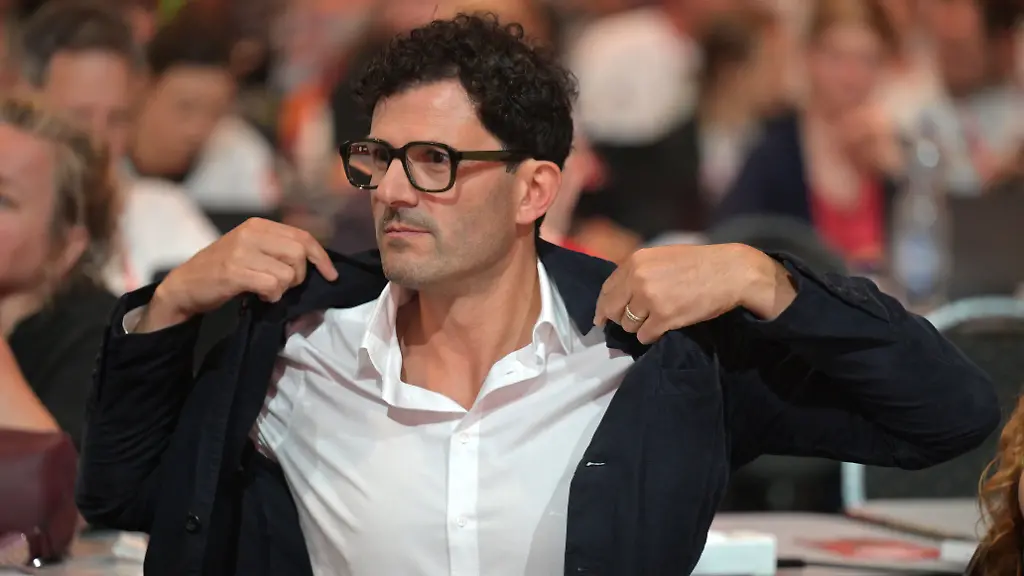 Luigi-Pantisano-Die-Linke-Parteivorsitzender-rueckt-sich-sein-Jackett-beim-Bundesparteitag-der-Linken-in-der-Metropolis-Halle-in-Potsdam-zurecht-Schwerpunkte-des-dreitaegigen-Parteitages-sind-die-Wahl-des-Parteivorstandes-und-die-inhaltliche-politisch-aktuelle-Debatte