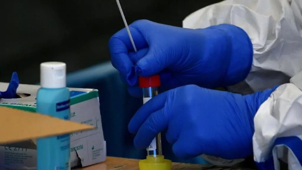 Mit-einem-Tupfer-nimmt-eine-Helferin-einen-Rachenabstrich