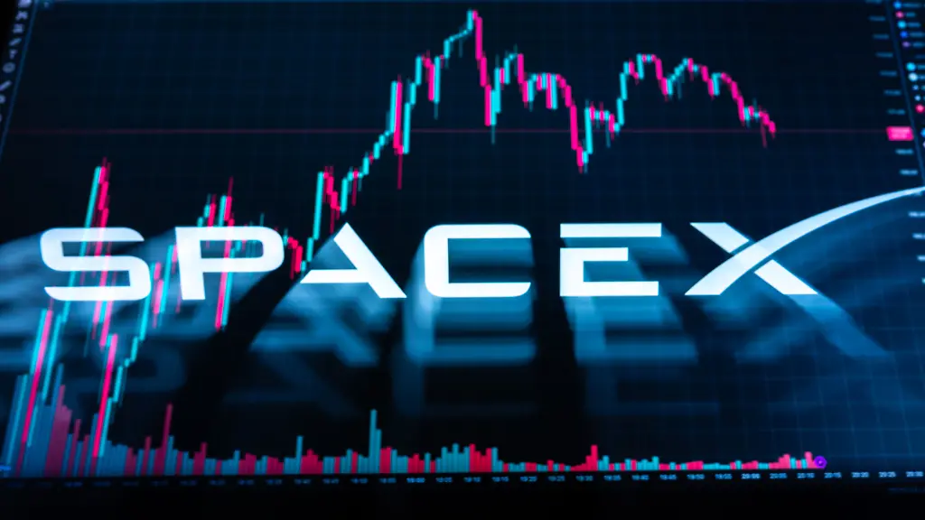 Das-Logo-des-US-amerikanischen-Raumfahrt-Telekommunikations-und-KI-Unternehmen-SpaceX-ist-auf-dem-Display-eines-MacBooks-vor-einem-Kerzenchart-der-SpaceX-Aktie-auf-Trading-View-zu-sehen-Aufnahme-mit-Langzeitbelichtung