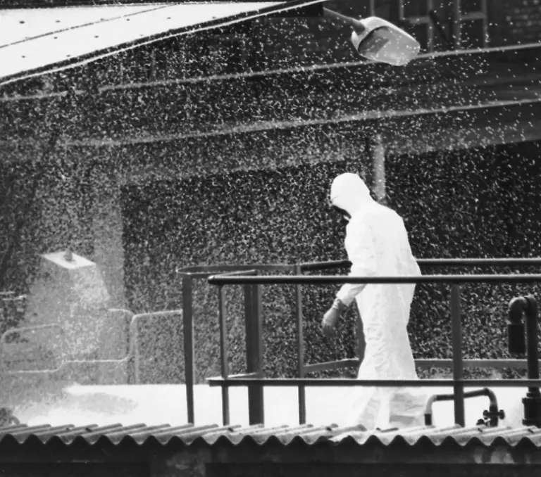 FILE-A-workman-of-the-Swiss-owned-chemical-plant-Icmesa-works-amidst-water-sprinklings-during-the-clearing-of-the-poisonous-cloud-of-highly-toxic-dioxin-spread-from-the-factory-reactor-after-it-exploded-on-July-10-1976-in-this-file-photo-taken-on-August-14-1976-The-long-term-effects-on-the-population-health-are-still-be-monitored-by-local-and-U-S-health-officials
