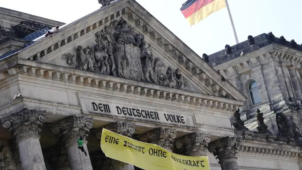 Greenpeace-Aktivisten-haengen-ein-Plakat-am-Reichstagsgebaeude-auf