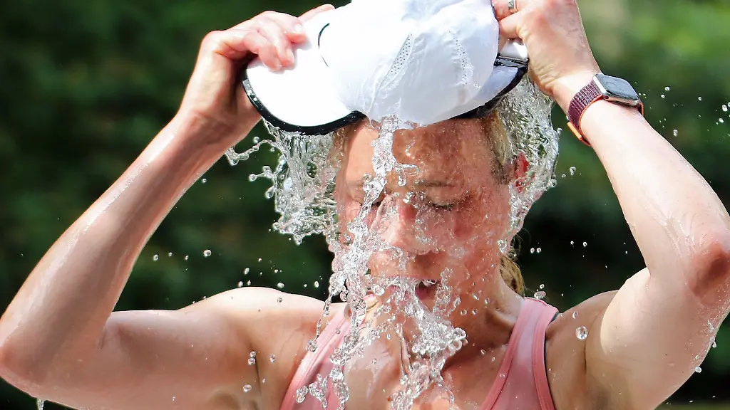 Eine-Laeuferin-beim-Hamburger-Halbmarathon-erfrischt-sich-an-einer-Wasserstelle