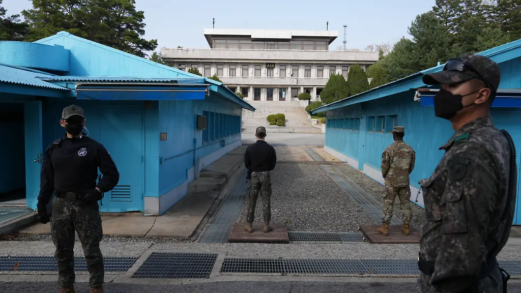 Soldaten-der-US-Armee-stehen-in-der-Joint-Security-Area-JSA-der-demilitarisierten-Zone-zwischen-Nord-und-Suedkorea-Im-Hintergrund-ist-der-Phanmun-Pavillon-auf-dem-Gebiet-von-Nordkorea-zu-sehen-Nach-dem-dreijaehrigen-Koreakrieg-war-im-Juli-1953-mit-dem-Waffenstillstands-Abkommen-eine-vier-Kilometer-breite-demilitarisierte-Zone-DMZ-eingerichtet-worden-die-bei-einer-Laenge-von-248-Kilometern-die-Grenze-zwischen-beiden-Laendern-markiert-In-einer-der-blauen-Baracken-l-im-Hauptquartier-in-der-JSA-war-der-Waffenstillstands-Vertrag-unterzeichnet-worden