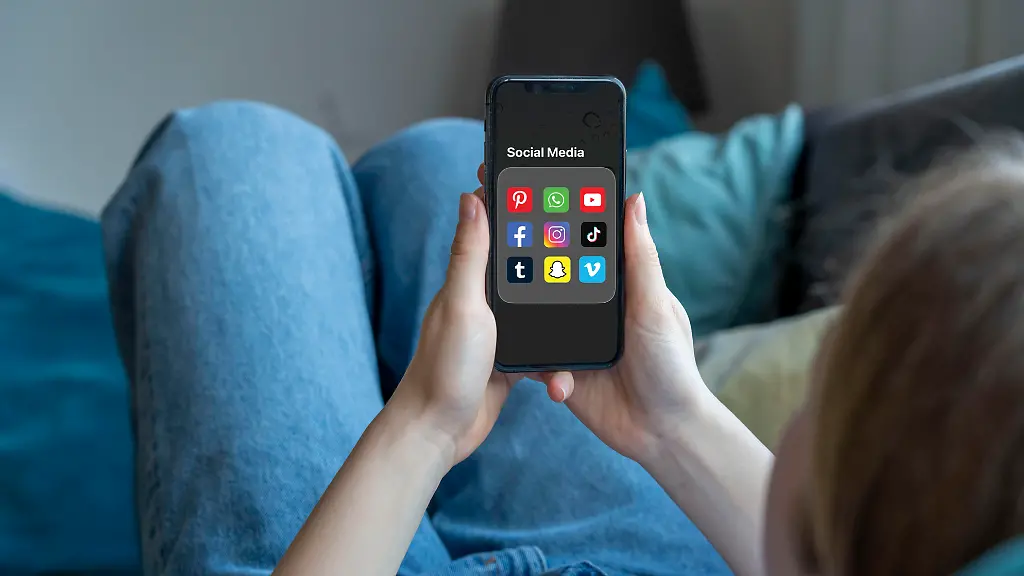 Symbolbild-Social-Media-Nutzung-von-jungen-Menschen-Kindern-junge-Frau-Maedchen-14-Jahre-alt-Ordner-mit-diversen-Social-Media-Plattformen-auf-dem-Handy