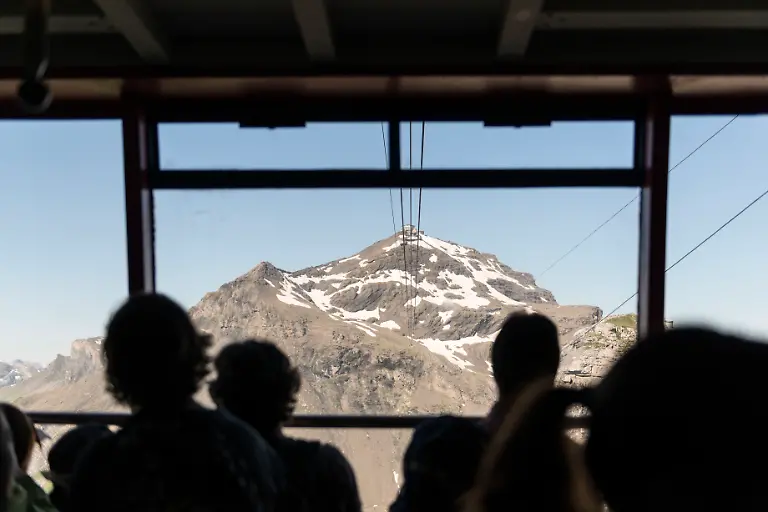 Touristen-sind-mit-der-Schilthornbahn-Richtung-Piz-Gloria-unterwegs-aufgenommen-am-6-August-2013-auf-dem-Schilthorn-in-Muerren-im-Berner-Oberland-Das-Schilthorn-mit-dem-Drehrestaurant-Piz-Gloria-war-Drehort-eines-James-Bond-Films-und-ist-im-Sommer-ein-beliebtes-Ausflugsziel-fuer-Touristen