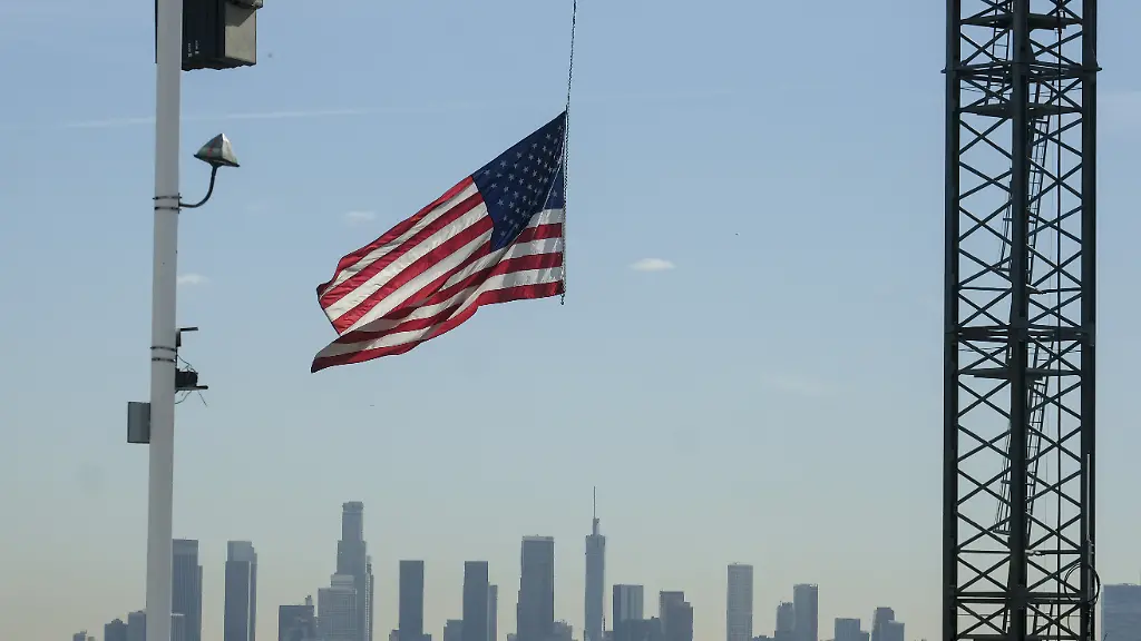 ARCHIV-27-11-2018-USA-Los-Angeles-Eine-US-Flagge-haengt-an-einem-Kran-auf-einer-Baustelle-in-Hollywood-Im-Hintergrund-ist-die-Skyline-von-Los-Angeles-zu-sehen-Das-US-Handelsministerium-veroeffentlicht-am-28-02-2019-die-Daten-zum-Bruttoinlandsprodukt-im-4-Quartal-und-Gesamtjahr-2018