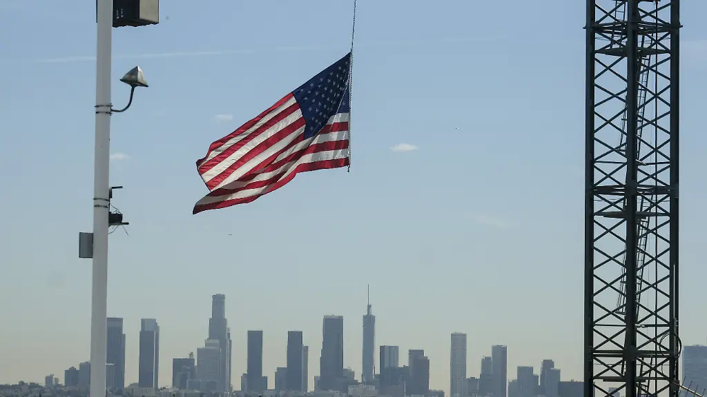 ARCHIV-27-11-2018-USA-Los-Angeles-Eine-US-Flagge-haengt-an-einem-Kran-auf-einer-Baustelle-in-Hollywood-Im-Hintergrund-ist-die-Skyline-von-Los-Angeles-zu-sehen-Das-US-Handelsministerium-veroeffentlicht-am-28-02-2019-die-Daten-zum-Bruttoinlandsprodukt-im-4-Quartal-und-Gesamtjahr-2018