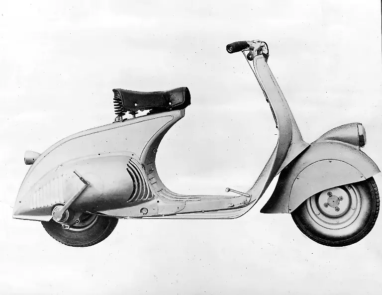 Der-Prototyp-von-1946-hatte-noch-98-ccm-aber-sonst-in-Linienfuehrung-und-Technik-bereits-alle-wesentlichen-Merkmale-der-inzwischen-beruehmt-gewordenen-Vespa-So-die-Anordnung-des-Motors-mit-Direktantrieb-auf-das-Hinterrad-die-selbsttragende-Karosserie-den-feinen-Durchstieg-und-die-einseitig-aufgehaengten-und-untereinander-auswechselbaren-Raeder-Die-Vespa-Nummer-Null-steht-im-Museum-von-Turin