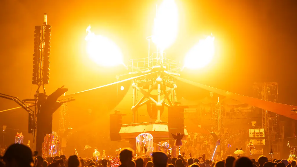 Lichteffekte-leuchten-an-der-Turmbuehne-auf-dem-Fusion-Festival-Wegen-Braenden-ausserhalb-des-Gelaendes-war-das-Festival-unterbrochen-worden-Bis-Sonntag-sollen-dort-mehr-als-3-300-Kuenstlerinnen-und-Kuenstler-auftreten-Die-Veranstalter-rechnen-mit-65-000-Besuchern-Das-jaehrlich-veranstaltete-Festival-an-der-Mecklenburgischen-Seenplatte-gilt-als-eines-der-groessten-alternativen-Musik-und-Kulturfestivals-Europas