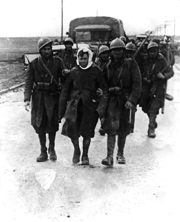 GREAT-BATTLES-IN-THE-GUADALAJARA-FRANCO-S-OFFENSIVE-ENDS-IN-ROUT-These-pictures-were-made-on-the-Guadalajara-front-near-Madrid-during-the-great-rebel-offensive-in-which-a-crushing-defeat-was-inflicted-on-General-Franco-s-forces-by-the-loyalists-With-General-Franco-s-mechanised-army-floundering-in-mud-thousands-of-Italians-who-were-fighting-on-the-rebel-s-side-retired-in-disorder-before-strong-Government-counter-attacks-PHOTO-SHOWS-Battle-Stained-rebel-soldiers-helping-a-wounded-comrade-along-the-Madrid-Saragossa-road-scene-of-a-determined-thrust-by-General-Franco-s-troops-during-the-Guadalajara-defensive