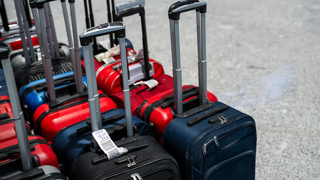 Mehrere-Rollkoffer-mit-Gepaeckanhaengern-stehen-bereit-fuer-die-Abfertigung-am-Flughafen-Die-Szene-zeigt-den-logistischen-Ablauf-der-Gepaecksortierung-und-den-Vorbereitungsprozess-fuer-ankommende-und-abfliegende-Passagiere-Am-Tag-des-Probebetriebs-fuer-den-neuen-Flugsteig-im-Terminal-1-des-Flughafens-Muenchen