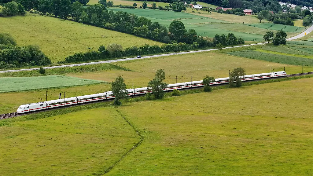Highspeed-auf-Schienen-Alltagsverkehr-auf-Asphalt-ein-ICE-der-Deutschen-Bahn-ueberholt-Autos-an-der-Bundesstrasse-bei-seiner-Fahrt-durch-gruene-Wiesen-naehe-Fulda-04-06-2026
