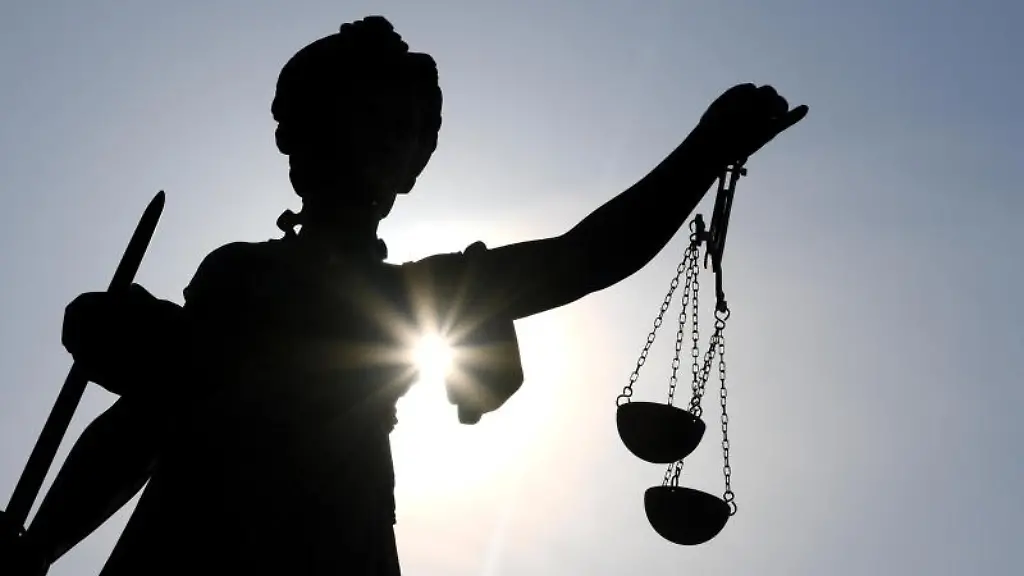 Die-Statue-der-Justitia-steht-im-Gegenlicht-der-Sonne