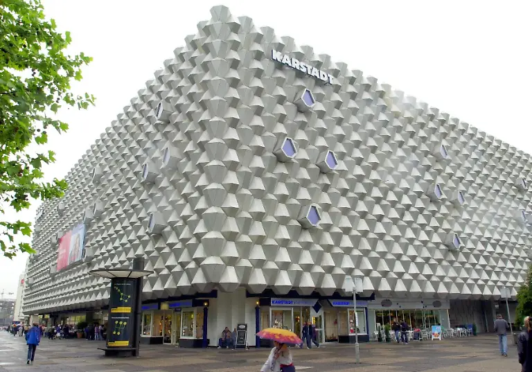 Dresden-Sachsen-Passanten-laufen-am-28-05-2002-vor-dem-Eingang-des-Karstadt-Kaufhauses-in-der-Dresdner-Innenstdt-Der-Einzelhandelskonzern-Karstadt-Quelle-AG-hat-wegen-der-Kaufzurueckhaltung-der-Verbraucher-in-den-ersten-drei-Monaten-des-Jahres-einen-Rueckgang-des-Konzernumsatzes-von-4-9-Prozent-verbucht-In-den-Warenhaeusern-fiel-der-Umsatz-nach-Unternehmensangaben-sogar-um-mehr-als-acht-Prozent-Die-vom-Vorstand-des-Konzerns-geplanten-Einsparungen-stossen-auf-den-heftigen-Widerstand-der-Mitarbeiter-Der-Warenhaus-und-Versandhandelskonzern-hatte-im-Mai-beschlossen-unter-anderem-die-Weihnachtszuwendung-die-Jahresabschlussverguetung-den-Krankengeldzuschuss-Leistungsloehne-und-Praemien-zu-streichen-Damit-sollen-60-Millionen-Euro-eingespart-werden-In-Sachsen-Anhalt-und-Sachsen-sind-nach-Unternehmensangaben-knapp-2000-Beschaeftigte-in-Dessau-Halle-Magdeburg-Leipzig-Dresden-Goerlitz-und-Hoyerswerda-betroffen